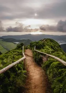 Explore a breathtaking hiking trail along a mountain ridge in the Azores during sunrise.